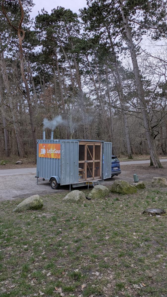 Saunatraileren i skoven med røg fra skorstenen